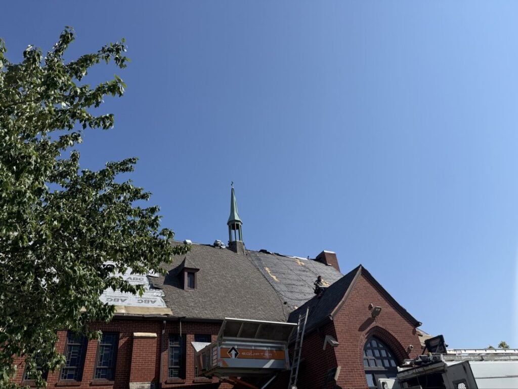 New shingles going on a brick church roof in Iowa
