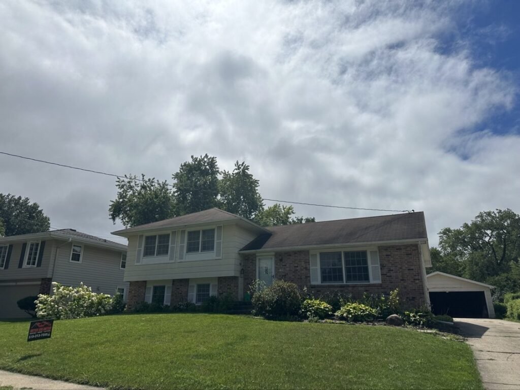 Split-level home with an old, worn asphalt shingle roof before replacement